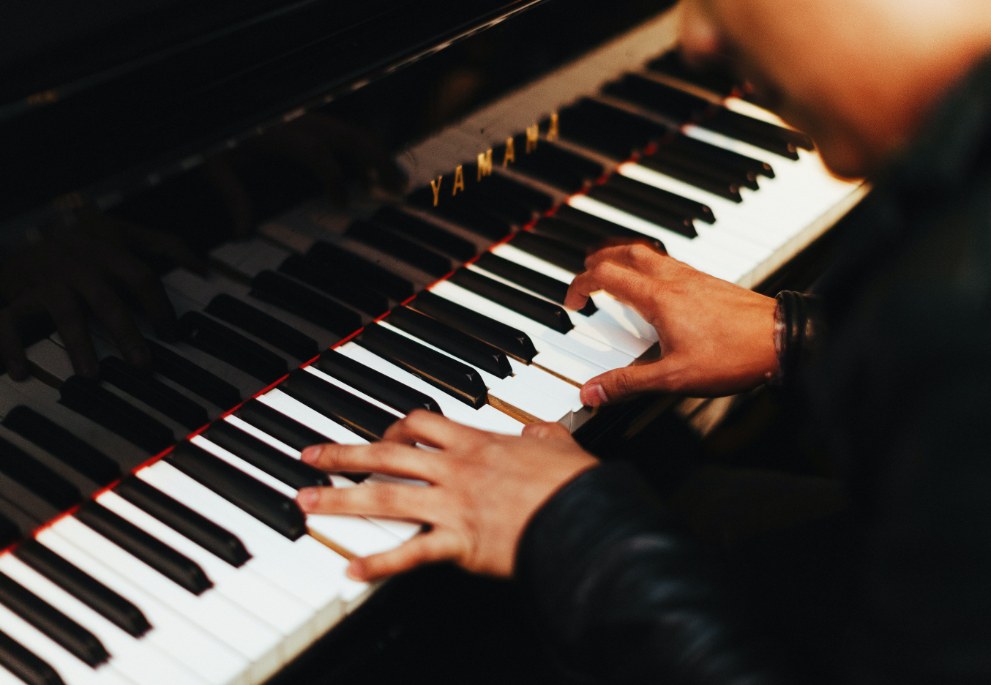 A close-up of young hands playing the piano.